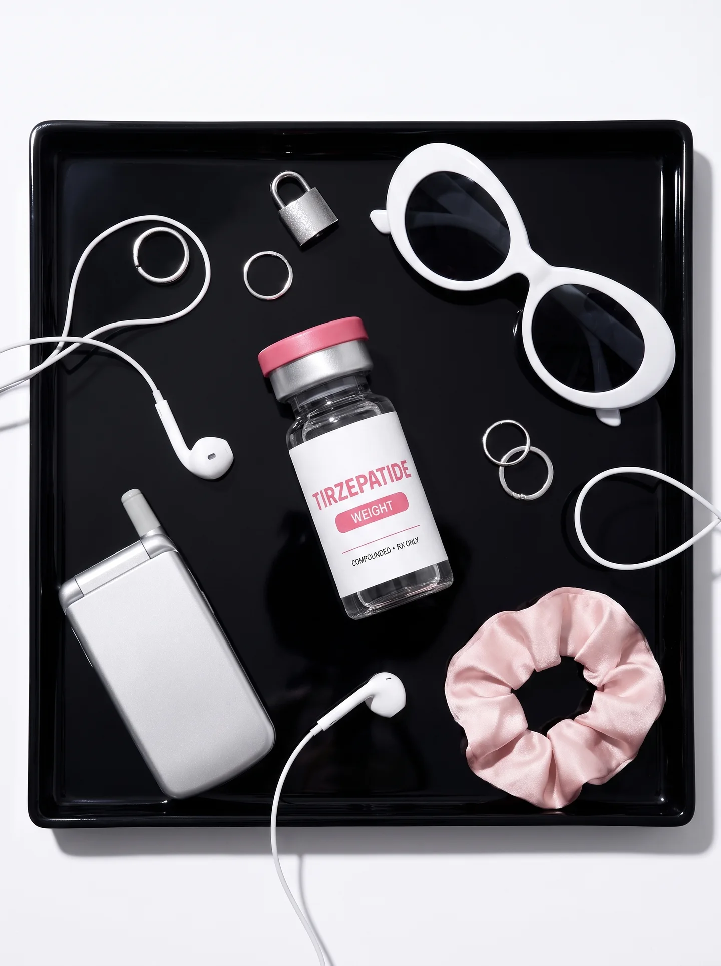 Labeled tirzepatide vial styled with fitness and self-care accessories