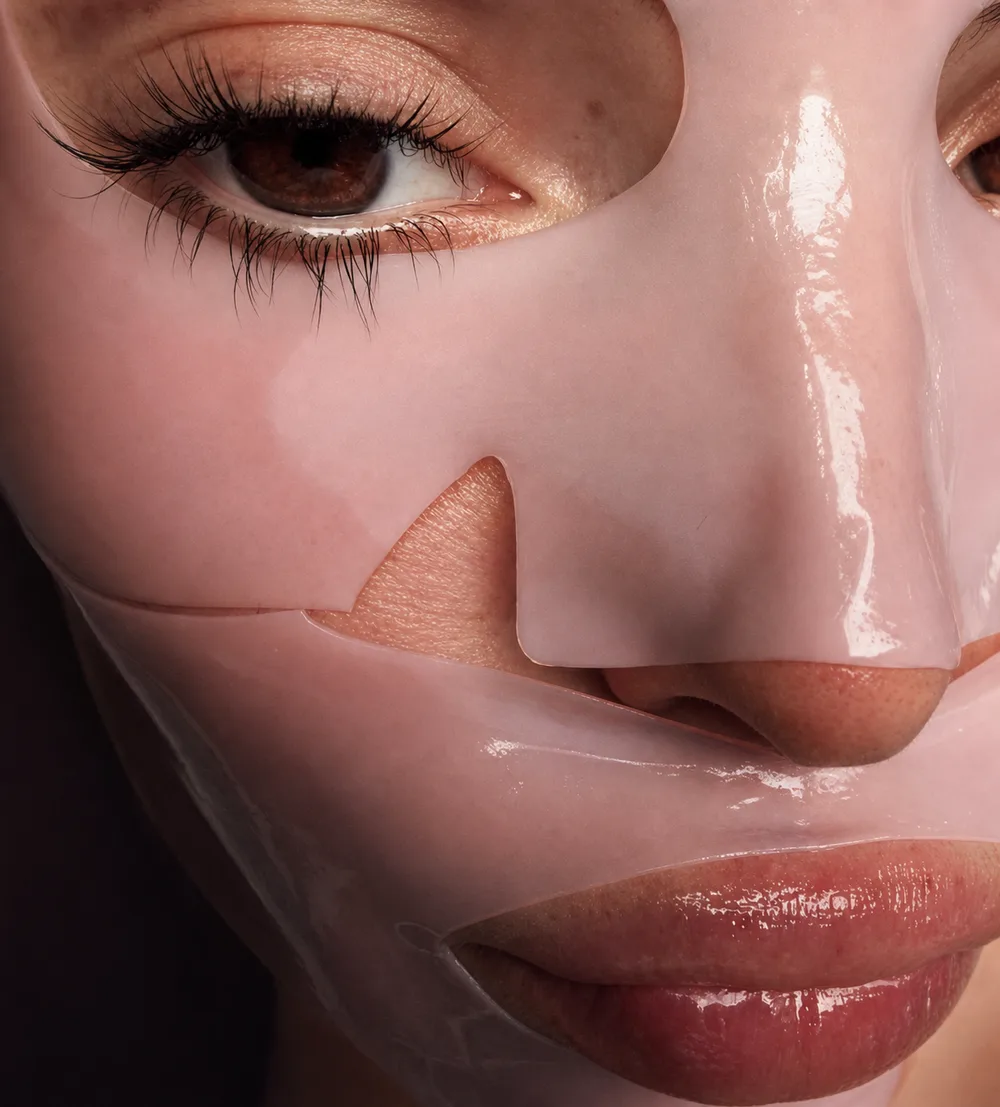 Editorial close-up of a glossy pink face mask